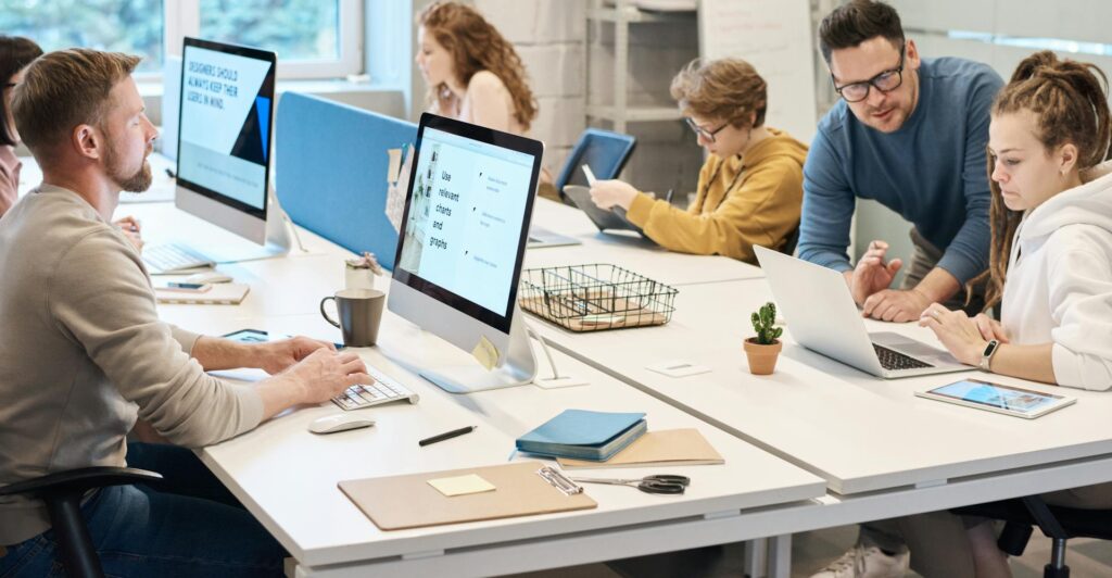 people working in office with computers in front of them